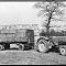 A Massey Harris Tractor pulling a trailer loaded with bales.